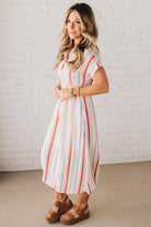 BLONDE WOMAN WEARING A RED AND WHITE DRESS WITH VERTICAL STRIPES, SIDE POCKETS, SHORT SLEEVE, BUTTON DOWN, FAUX TIE WAIST AND MIDI LENGTH.