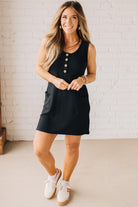 BLONDE WOMAN MODELING A RIBBED TANK DRESS WITH HENLEY STYLE WOOD BUTTONS AND TWO FRONT POCKETS