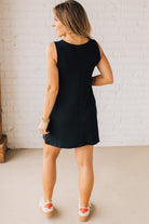 BLONDE WOMAN MODELING A RIBBED TANK DRESS WITH HENLEY STYLE WOOD BUTTONS AND TWO FRONT POCKETS