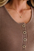BLONDE WOMAN MODELING A RIBBED TANK DRESS WITH HENLEY STYLE WOOD BUTTONS AND TWO FRONT POCKETS