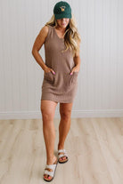 BLONDE WOMAN MODELING A RIBBED TANK DRESS WITH HENLEY STYLE WOOD BUTTONS AND TWO FRONT POCKETS