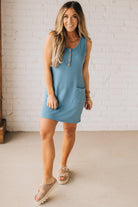 BLONDE WOMAN MODELING A RIBBED TANK DRESS WITH HENLEY STYLE WOOD BUTTONS AND TWO FRONT POCKETS