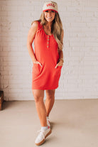 BLONDE WOMAN MODELING A RIBBED TANK DRESS WITH HENLEY STYLE WOOD BUTTONS AND TWO FRONT POCKETS