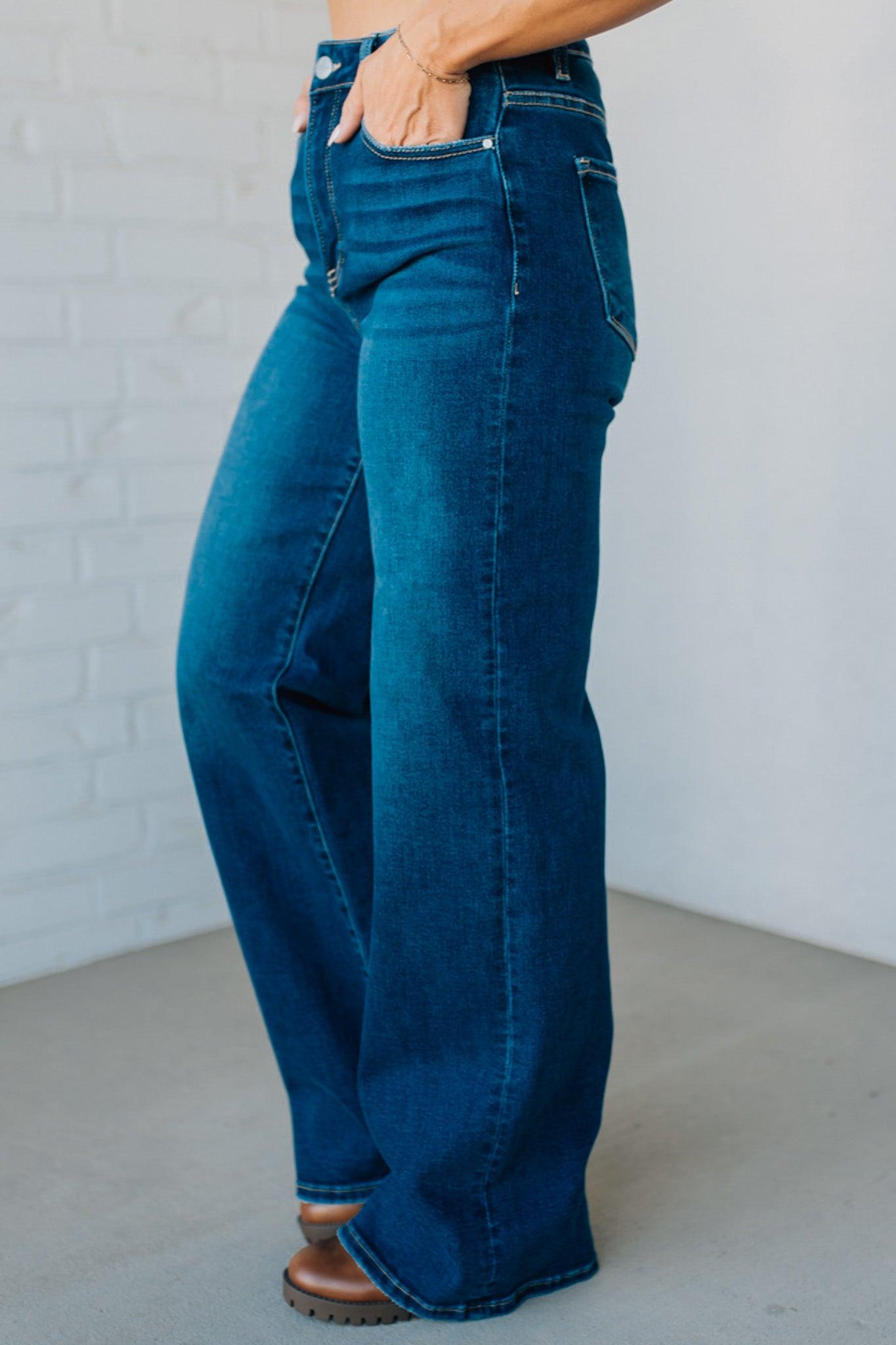 Person wearing blue jeans against a plain background
