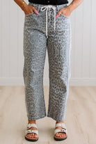 Person wearing leopard print pants with a white background