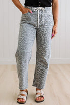 Person wearing gray leopard print pants with a white background