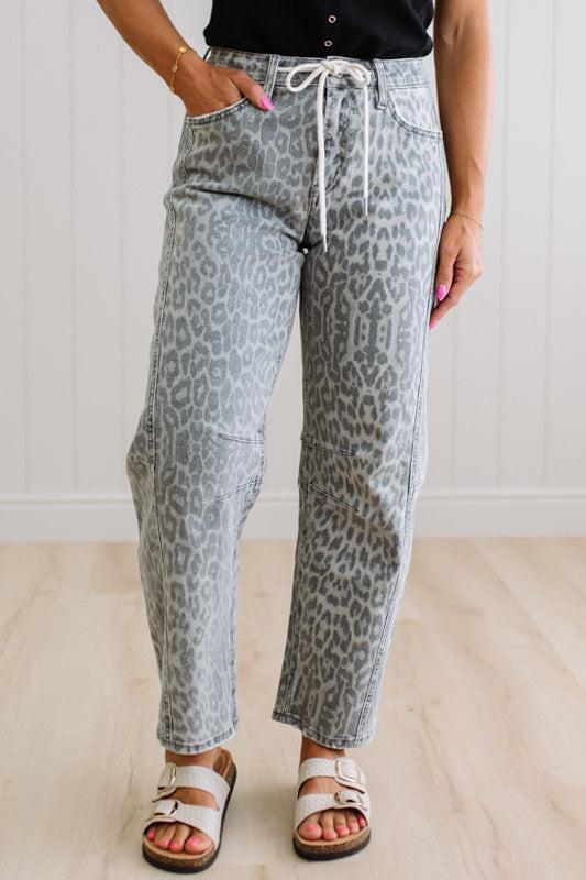 Person wearing gray leopard print pants with a white background