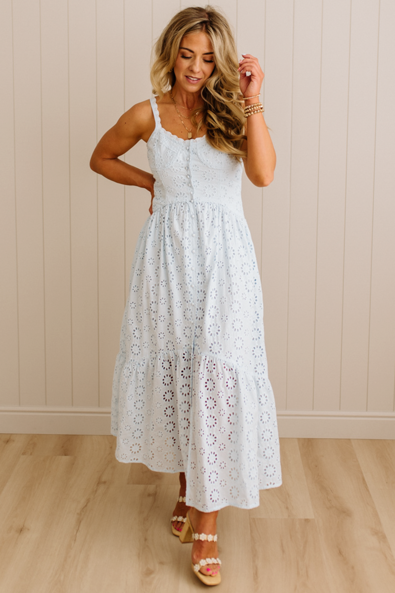 Blonde Woman wearing an eyelet lace dress with button front and spaghetti strap.