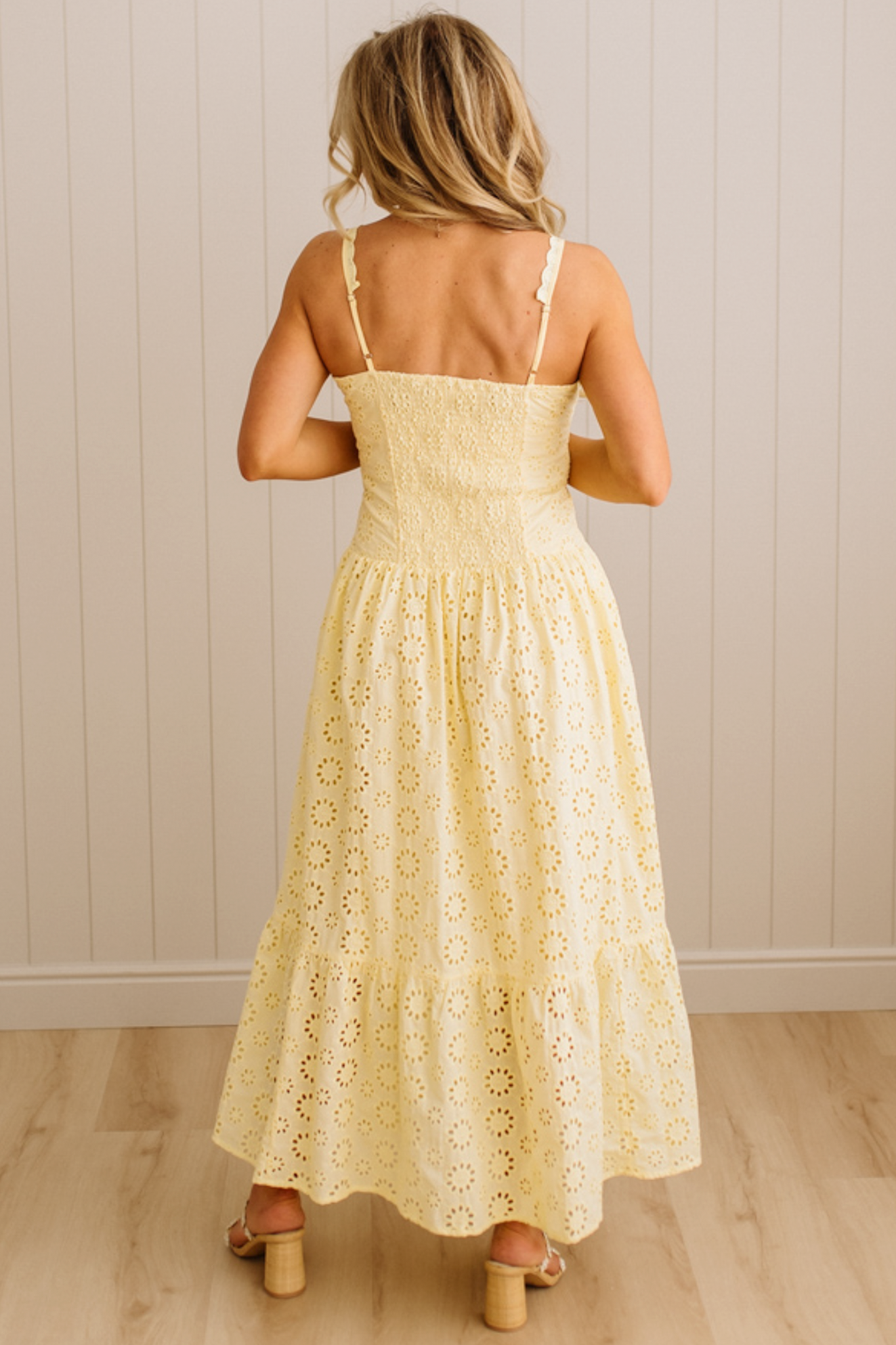 Blonde Woman wearing an eyelet lace dress with button front and spaghetti strap.