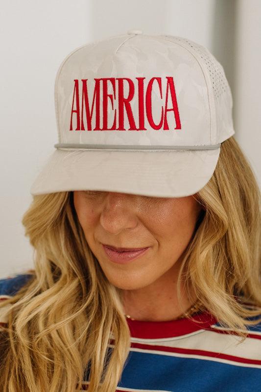 Person wearing a beige cap with 'AMERICA' in red text against a white background