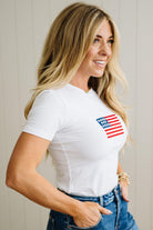Woman wearing a white t-shirt with a small American flag design.