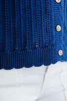 Close-up of a blue knitted cardigan with buttons on a white background