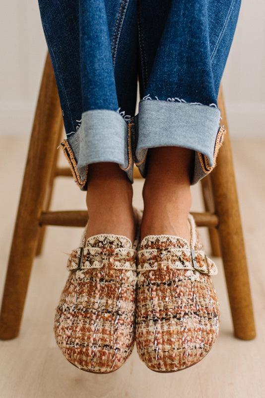 Womens footwear featuring a woven tweed upper with a statement buckle detail, set in an easy mule silhouette.