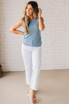 BLONDE WOMAN WEARING A ROUND NECK SLEEVELESS SLUB KNIT TOP.