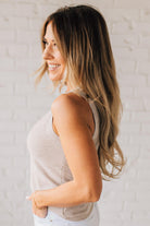 BLONDE WOMAN WEARING A ROUND NECK SLEEVELESS SLUB KNIT TOP.