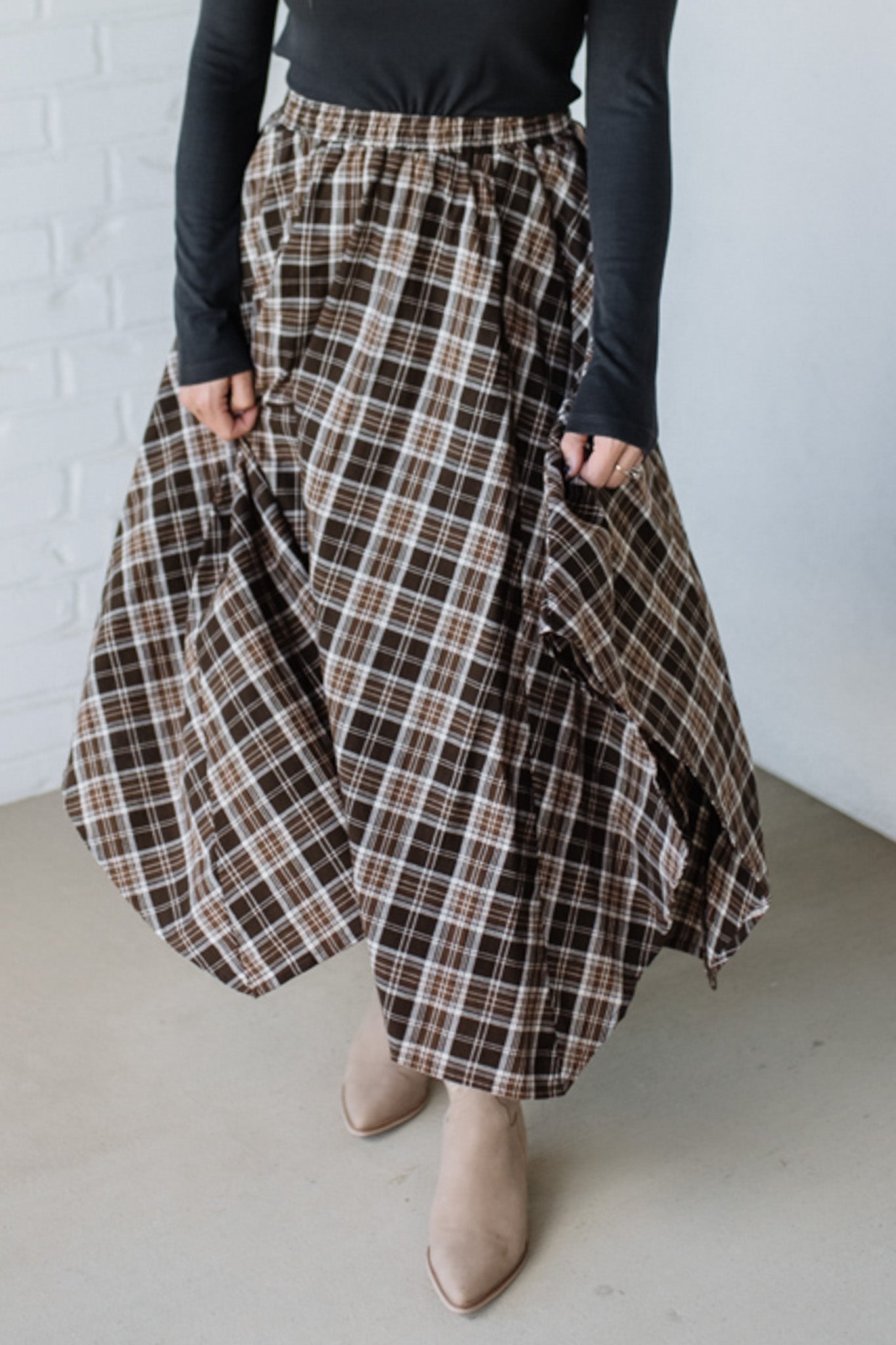 Person wearing a plaid skirt with a plain background