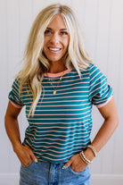 Woman wearing a green and white striped shirt with a plain background