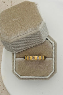  Gold ring with cubic zirconia baguettes all the way around.