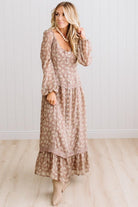 Latte brown colored Floral Drop Waist Maxi Dress on a blonde woman with a large white beaded necklace.
