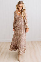 Latte brown colored Floral Drop Waist Maxi Dress on a blonde woman with a large white beaded necklace.