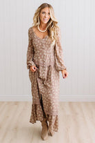 Latte brown colored Floral Drop Waist Maxi Dress on a blonde woman with a large white beaded necklace.