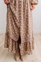 Latte brown colored Floral Drop Waist Maxi Dress on a blonde woman with a large white beaded necklace.