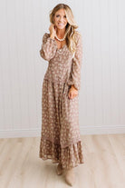 Latte brown colored Floral Drop Waist Maxi Dress on a blonde woman with a large white beaded necklace.