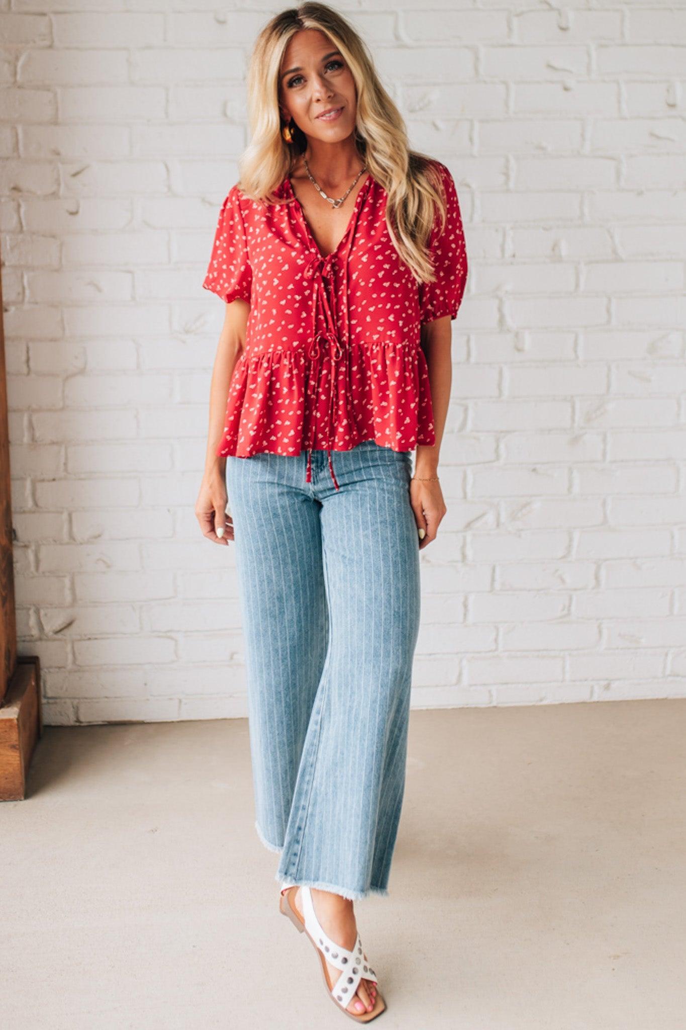 Blonde Woman Wearing a Red Top with White Dots, Front Ties, and Puff Half Sleeves.