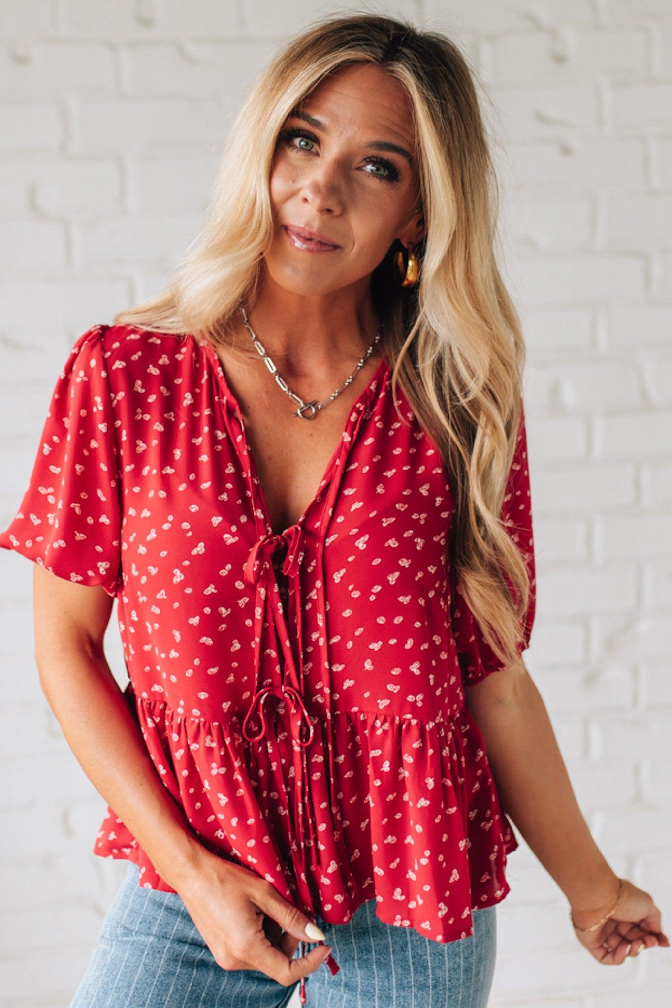 Blonde Woman Wearing a Red Top with White Dots, Front Ties, and Puff Half Sleeves.