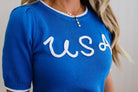 Blue sweater with 'USA' text worn by a person