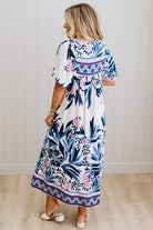 Blonde woman wearing a long printed maxi dress in blue and white with hot pink accents.