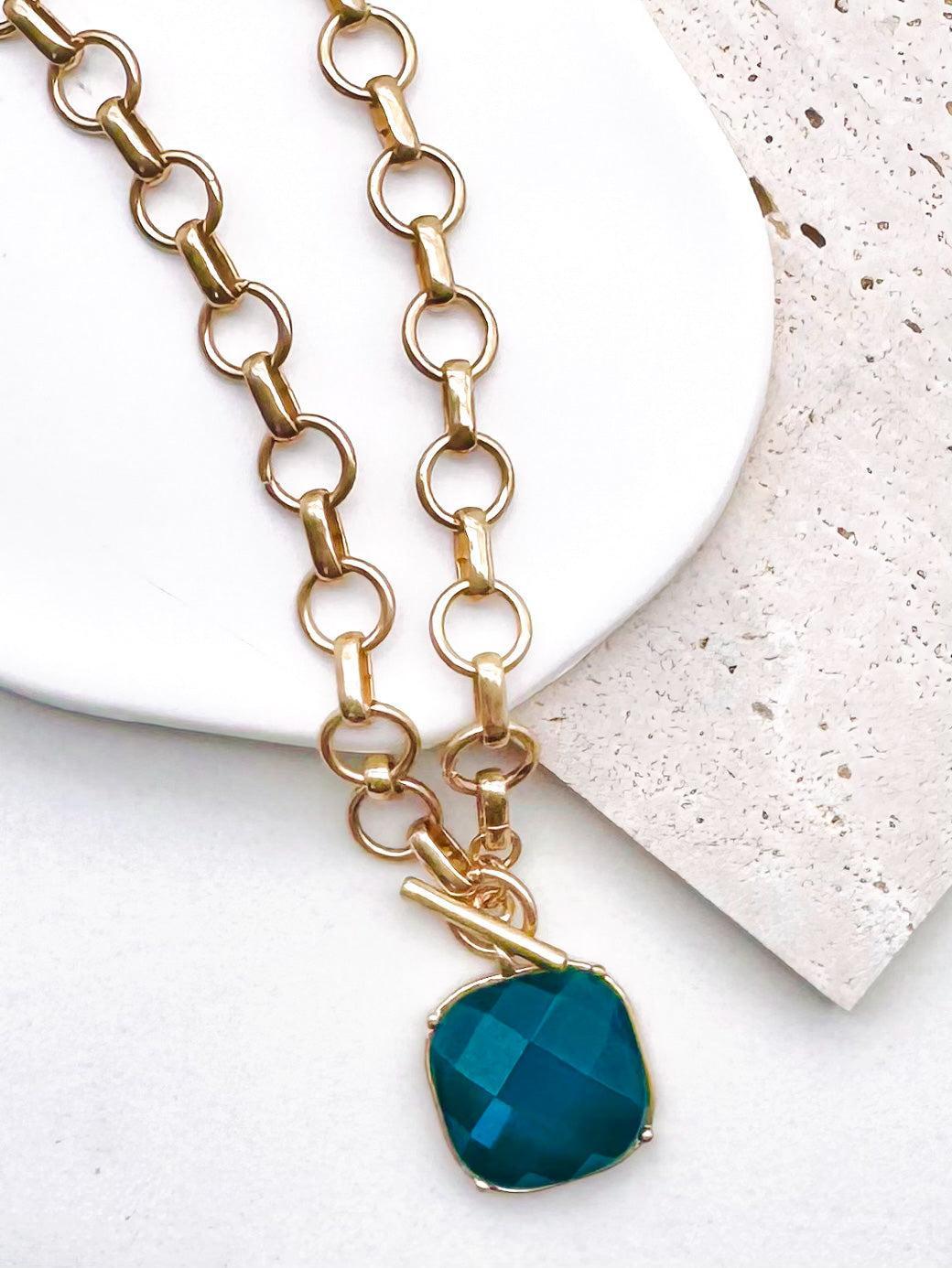Uniform matte circle links meet at a working toggle front where a bezel framed cushion stone swings freely below the bar. Necklace length: 18 inches. The brushed finish plays against the glassy faceted surface for a tactile designer inspired contrast.