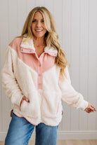 Woman wearing a pink and white fleece jacket with a neutral background