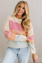 Woman wearing a colorful patterned sweater against a neutral background
