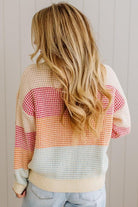 Person wearing a colorful sweater with a neutral background