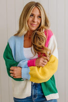Woman wearing a colorful sweater with a neutral background