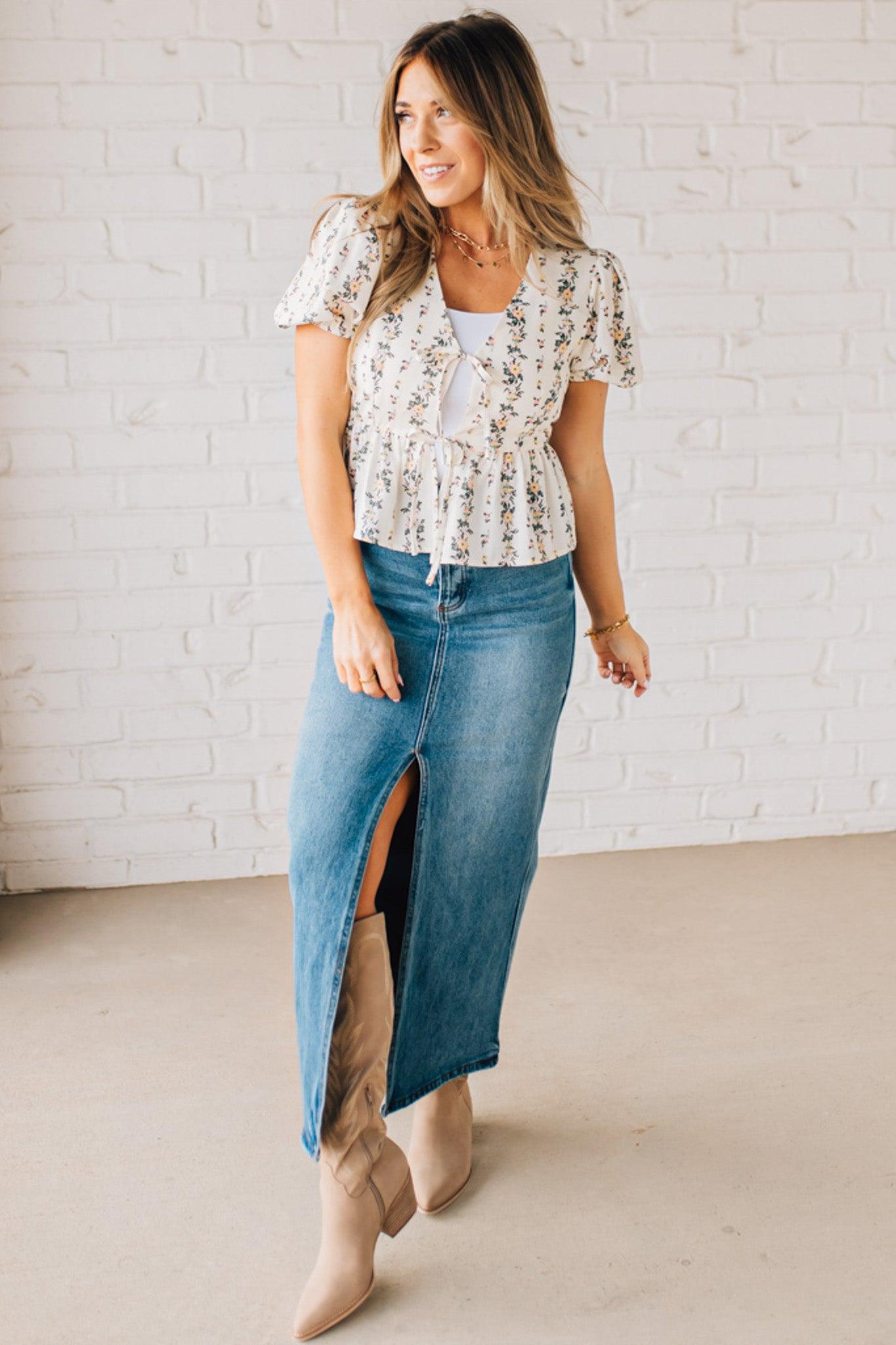 Blonde woman wearing a floral print tie front shirred hem blouse top with puff sleeve.