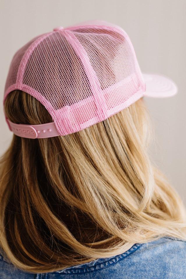 Person wearing a pink mesh cap with a neutral background