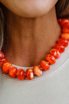 Colorful Bead Necklace in bright orange on a woman's neckline.
