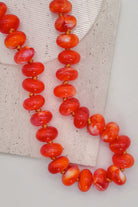 Colorful Bead Necklace in bright orange on a textured surface