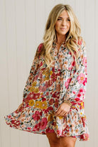 Woman wearing a floral dress against a white wall