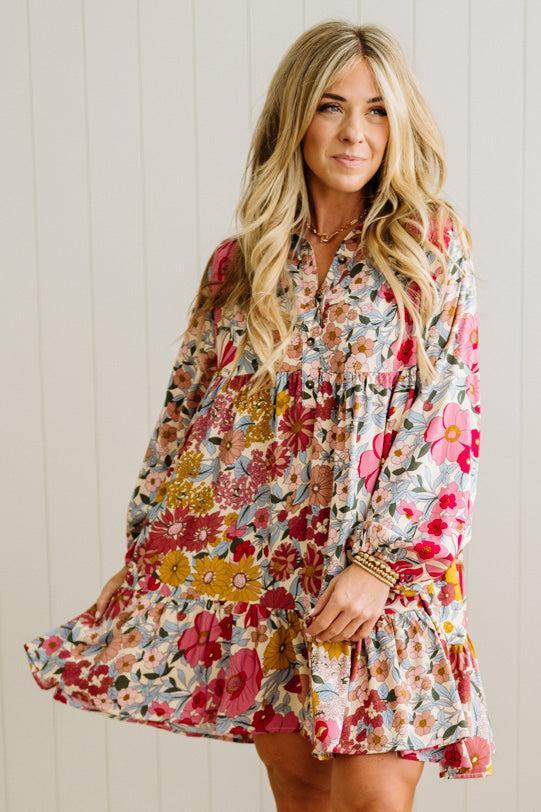 Woman wearing a floral dress against a white wall