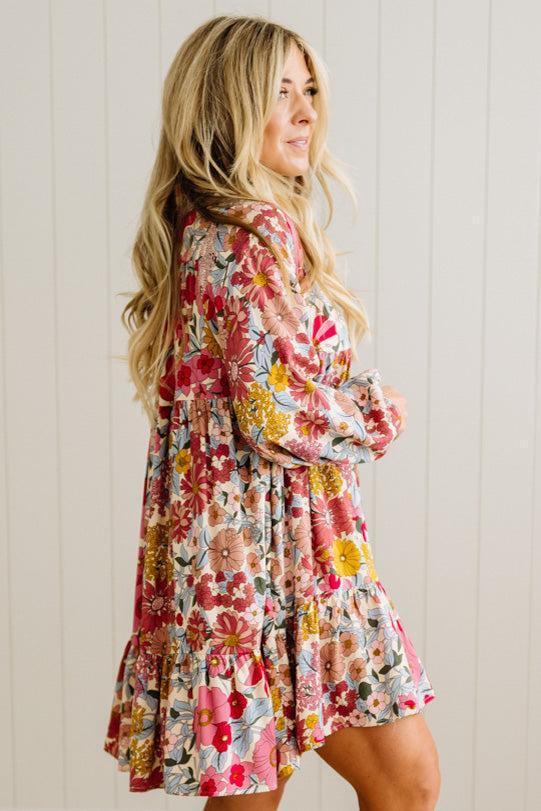 Woman wearing a floral dress against a white paneled wall