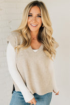 BLONDE WOMAN WEARING AN OVERSIZED SWEATER VEST WITH SIDE SLIT