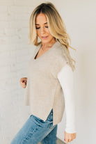 BLONDE WOMAN WEARING AN OVERSIZED SWEATER VEST WITH SIDE SLIT