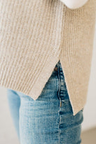 BLONDE WOMAN WEARING AN OVERSIZED SWEATER VEST WITH SIDE SLIT