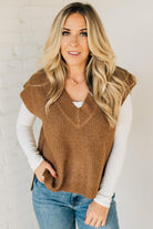 BLONDE WOMAN WEARING AN OVERSIZED SWEATER VEST WITH SIDE SLIT