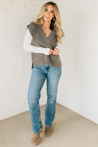 BLONDE WOMAN WEARING AN OVERSIZED SWEATER VEST WITH SIDE SLIT