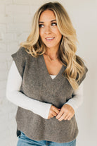 BLONDE WOMAN WEARING AN OVERSIZED SWEATER VEST WITH SIDE SLIT