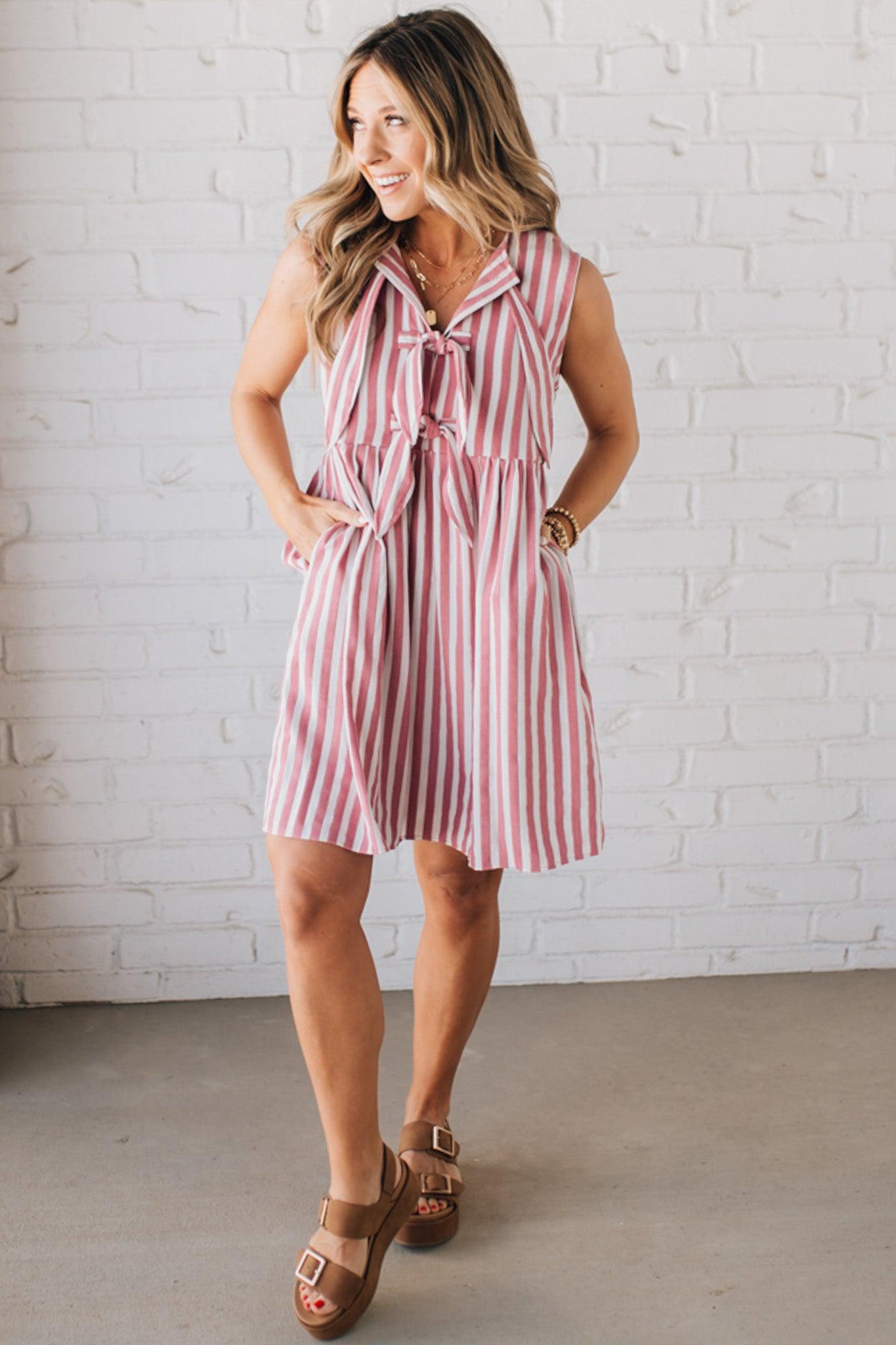 BLONDE WOMAN WEARING VERTICAL STRIPED TRIPLE FRONT BOW DETAIL MINI DRESS.